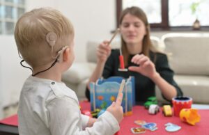 Adult interacting with young child with cochlear implant