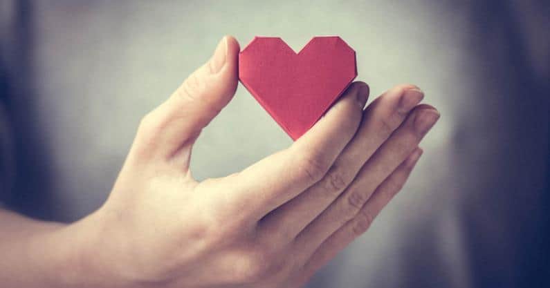 Photo of hand holding a cut-out paper heart