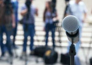 Photo of public speaking with close-up of microphone