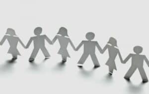 Photo of paper cut-outs of diverse people holding hands