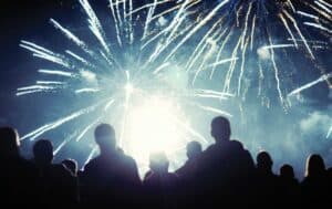 Photo silhouette of a group of people people watching fireworks outside