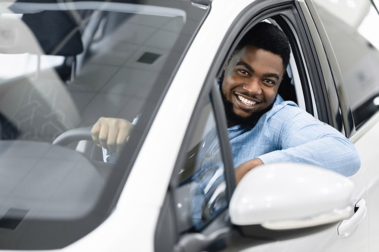 Car,Owner.,Joyful,Afro,Guy,Smiling,To,Camera,Sitting,In GEICO Auto Insurance Member Benefit