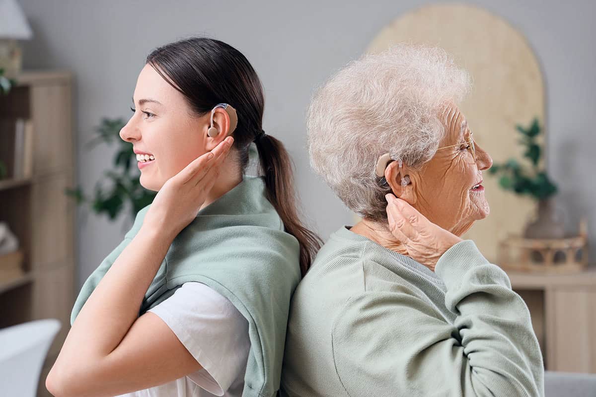 Senior,Woman,And,Her,Granddaughter,With,Hearing,Aids,At,Home Senior woman and her granddaughter with hearing aids at home