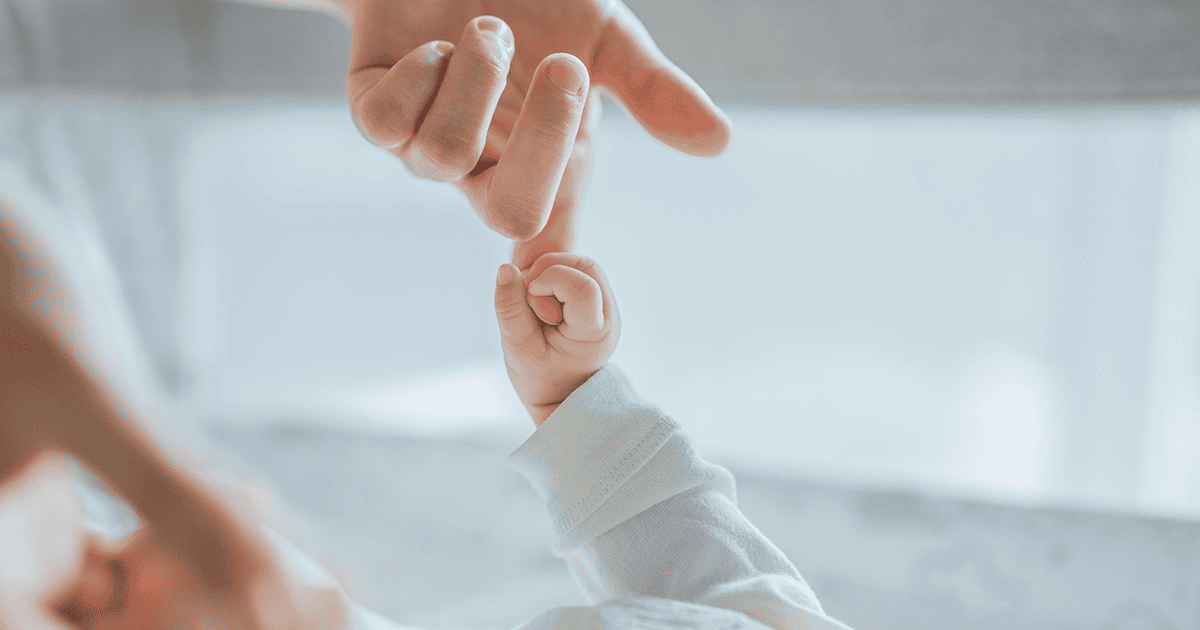 Little hand of child baby holding hand of mother, - Newborn Hearing Screenings Made Easier: Why Did We Never Think of This?