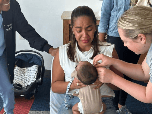 Audiologist Dr. Ashlee Vandiver fits a hearing aid on an infant while on a mission trip to La Romana in the Dominican Republic in collaboration with the Portland, Maine Rotary.