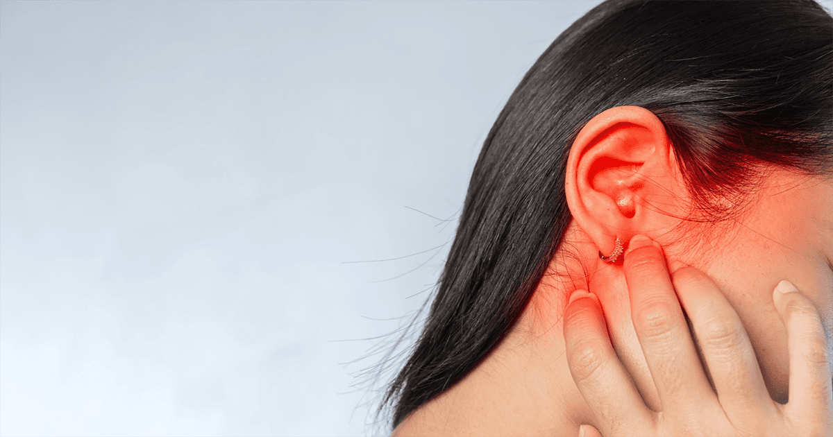 Close-up of a woman examining her ear, highlighting audiology and hearing health services.