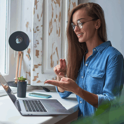 happy-young-smiling-casual-woman-learning-communicates-sign-language-online-laptop-cozy-comfy-home-by-window